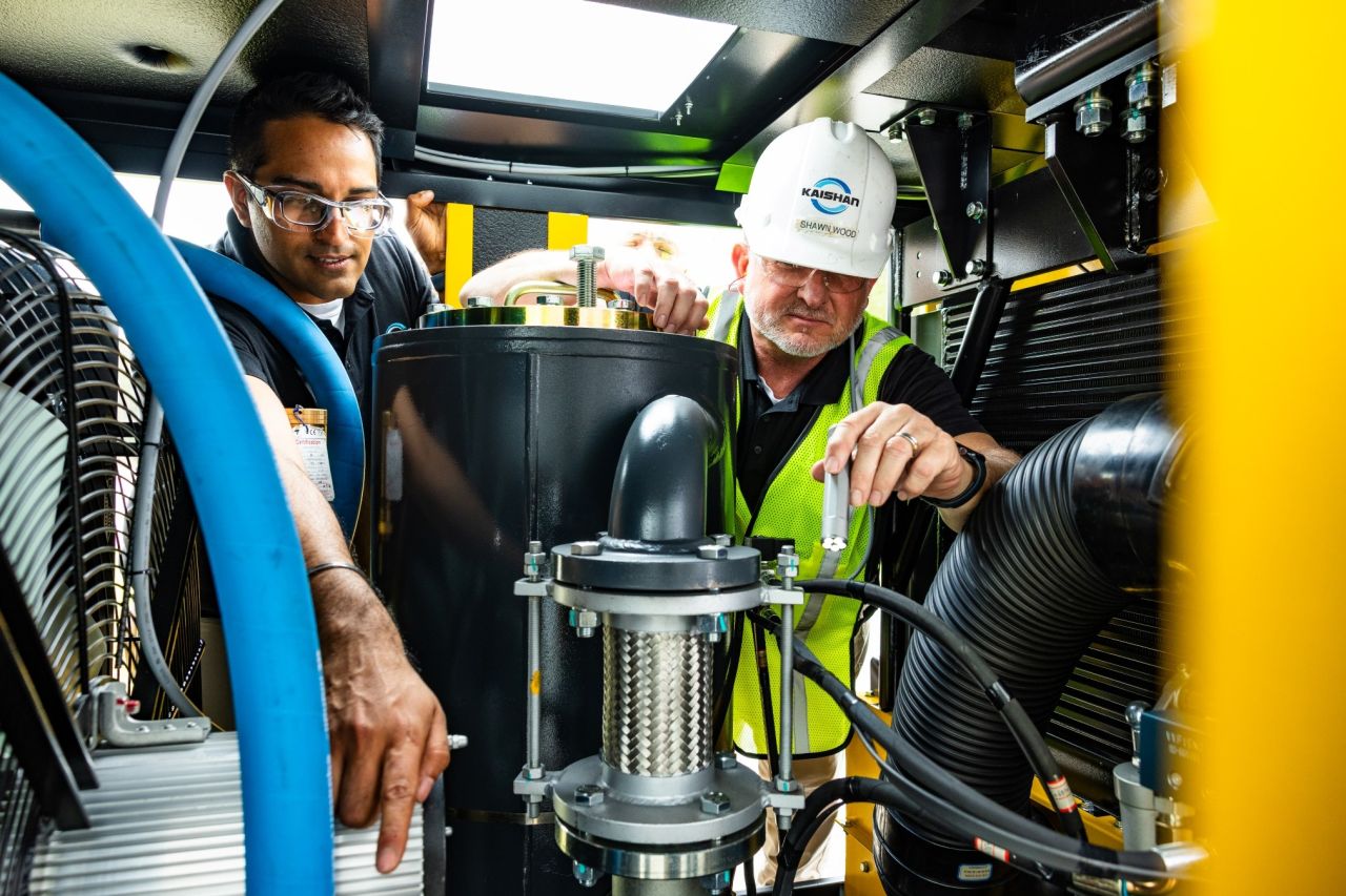 Two technicians in safety gear inspect the internal components of a large industrial machine in one of the nation’s top 10 states for doing business.